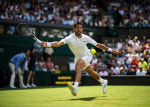 Novak Djokovic reaching at Wimbledon